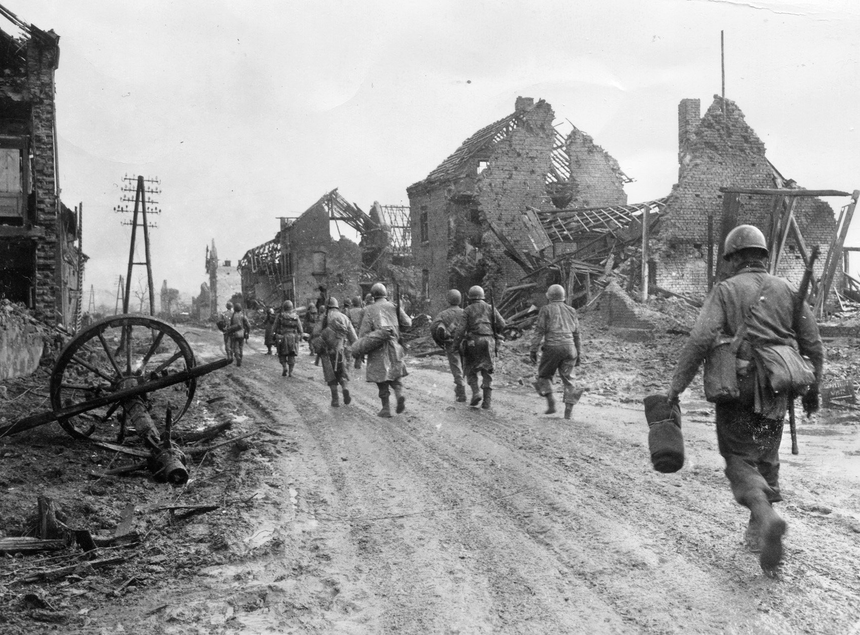 Men of the 121st Infantry Regiment, 8th Infantry Division, head out of the destroyed town of Hürtgen and advance toward Kleinau and the start of the attack to capture the Brandenberg-Bergstein Ridge.